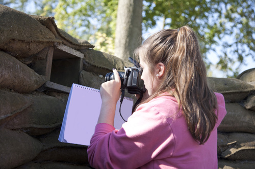 A student looks through a gap in the trenches to understand what a soldier positioned there may have experienced.