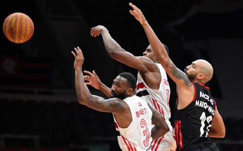 Basketball players blocking a pass