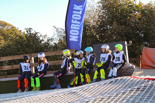 A group of young skiers wait to be called up for their first run.