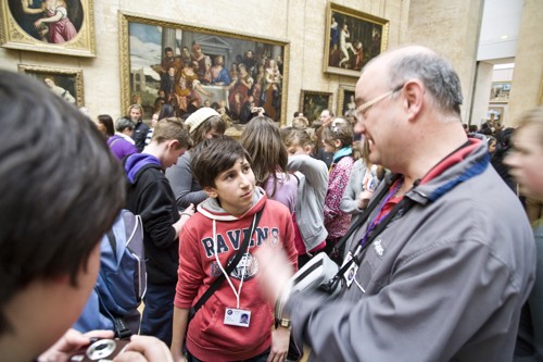 A student discusses art with his teacher in a gallery