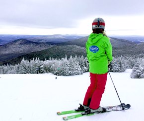 young female skier overlooking ski resort | Equity - the school travel people